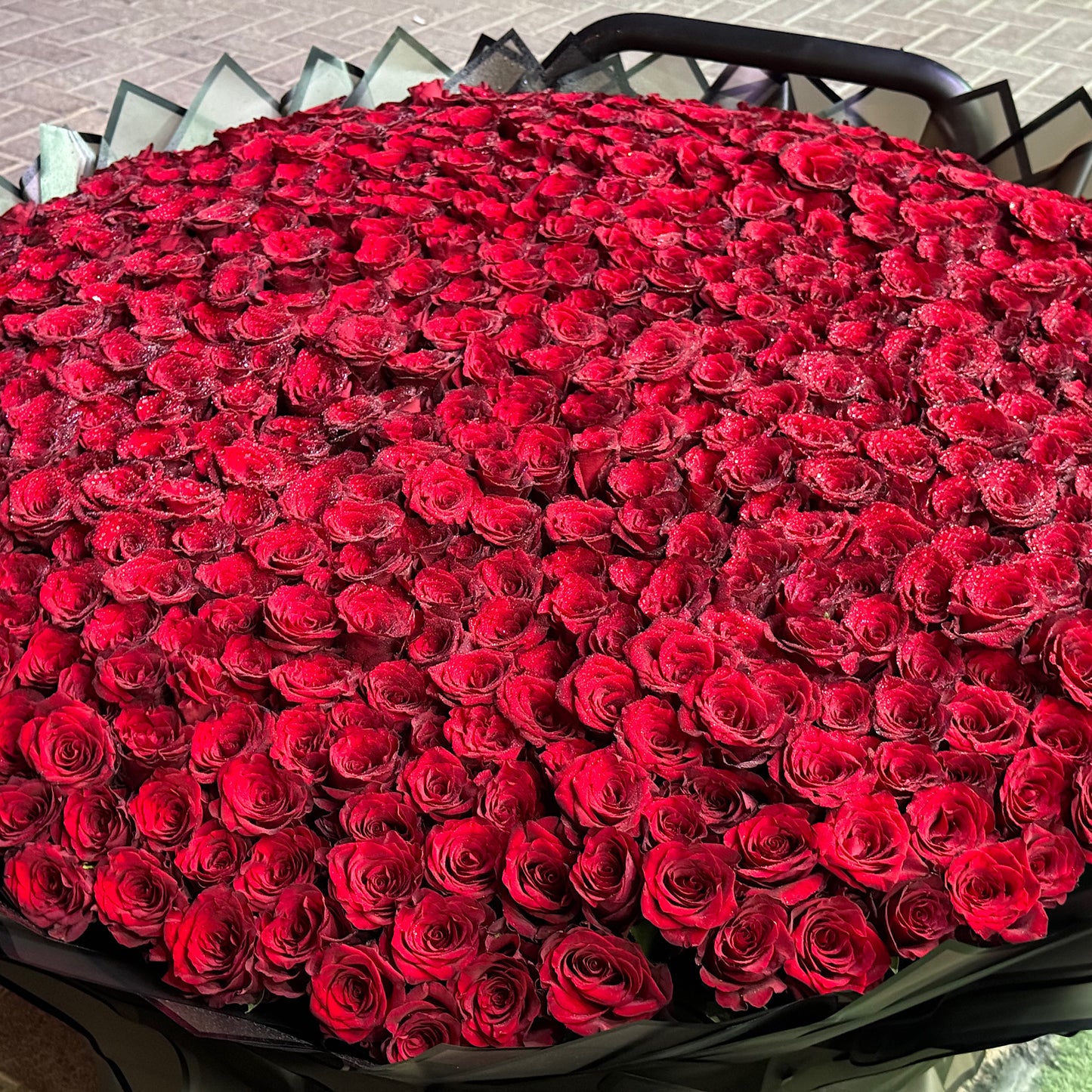 Large bouquet of red roses in a black container.
