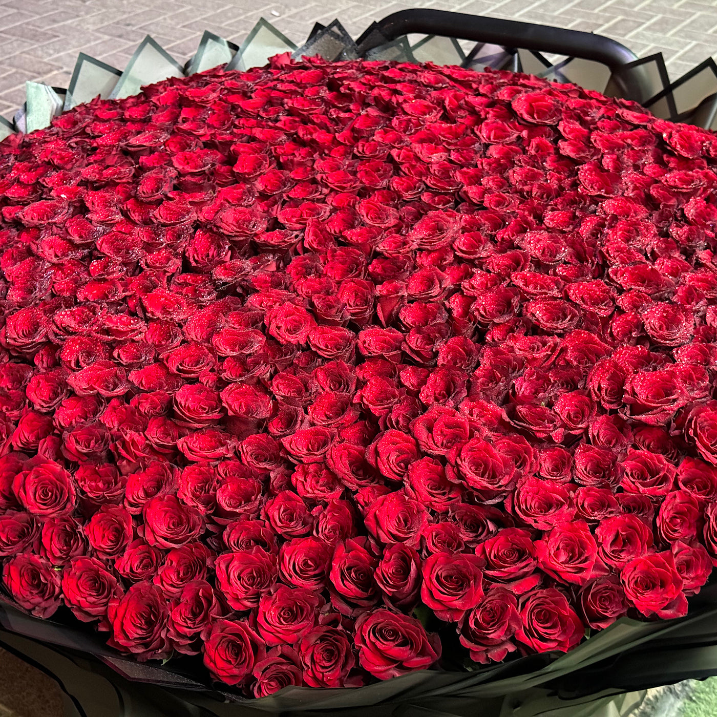 Large bouquet of red roses in a black container.