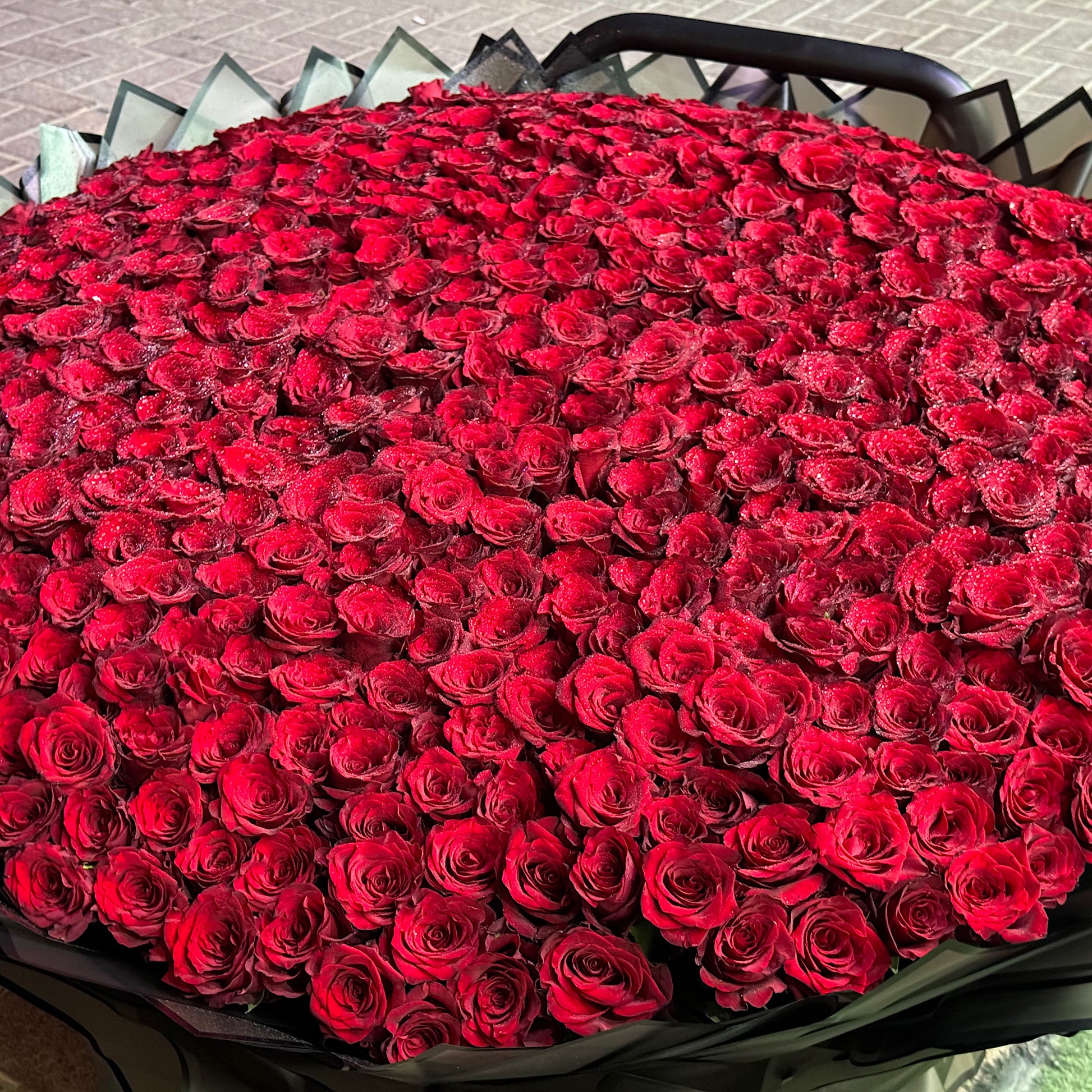 Large bouquet of red roses in a black container.